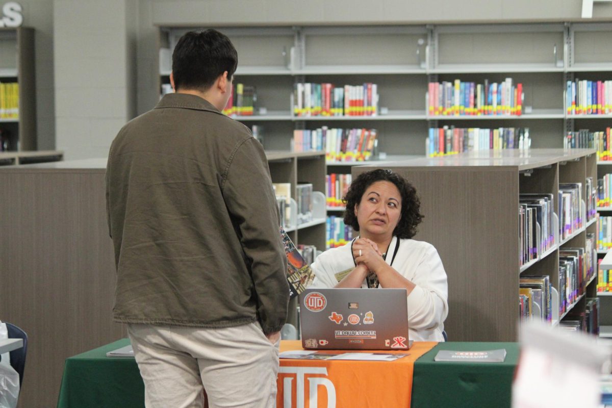 Christian Villatoro (12), interacts with The University of Texas at Dallas (UTD) during the spring college fair in the library on April 2nd. Villatoro walked up as he is considering applying there. “It has a highly regarded medical program and a spacious campus,” Villatoro said.

